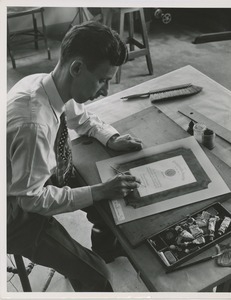 A man making the painted proof of the 1951 president's trophy plaque