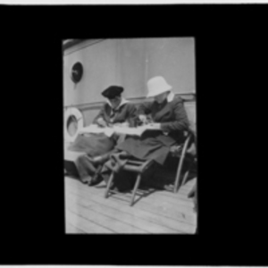 Two women, eating on deck