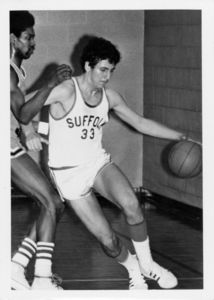 Suffolk University men's basketball player Chris Tsiotos (#33) dribbles past a defender during a game, 1975