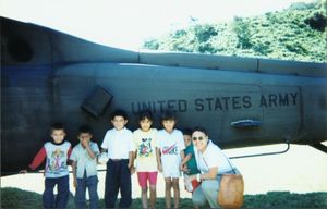 Gladys Rodriguez with children in front of helicopter in El Salvador, November 1997
