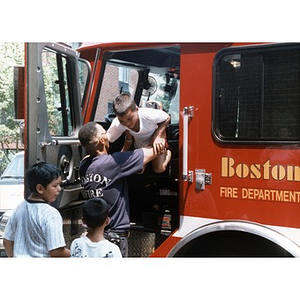Children boarding a Boston Fire Department truck at Festival Betances.