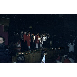 Children singing on stage at the Jorge Hernandez Cultural Center during a Three Kings Day celebration.