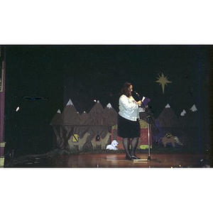 Woman at the microphone on stage during Three Kings Day celebration.