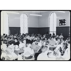 Children and adults sit around tables in an auditorium, looking to the front during a Boys' Clubs of Boston Awards Night