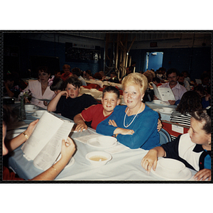 A woman and a boy seated at a table smiling for the camera during a Boys and Girls Club Awards Night