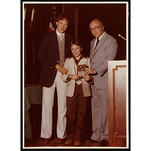 Steven Roache receives an award from Robert Cleary, Overseer of the Boys' Clubs of Boston, at right, and an unidentified man