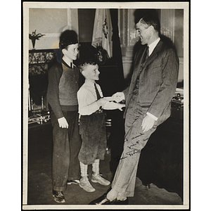 A man presents an award to a boy as another looks on at a Boys' Club awards event