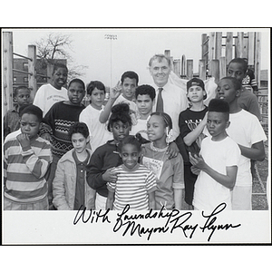 Mayor Raymond Flynn posing with fifteen Boys and Girls Club members in a playground