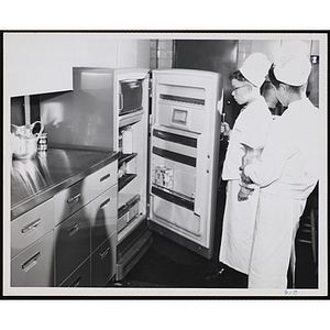 Two members of Tom Pappas Chefs' Club look inside a refrigerator