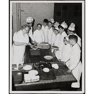 Members of the Tom Pappas Chefs' Club watch Chefs' Club Committee member Mary Sciacca assemble a dish