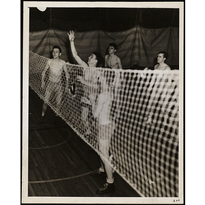 Five teenage boys play volleyball in a gymnasium