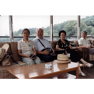 Men and women sit together on sofas and armchairs during an Association trip to China