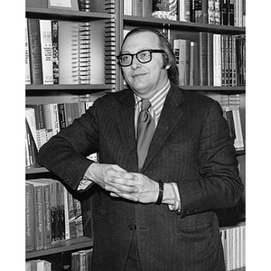 Professor Raymond Robinson stands by a bookcase