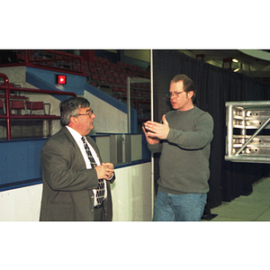 Two men discuss preparations for President Freeland's inauguration