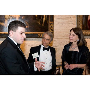 Two men and a woman converse at the inauguration celebration for President Aoun