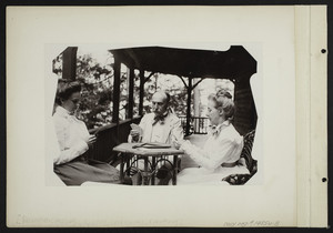 Three people playing a card game, location unknown, undated
