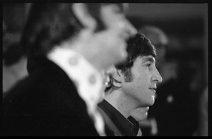 John Lennon at a Beatles press conference, with Ringo Starr in the foreground