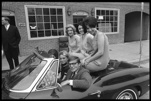 JOPA staff member with five women packed into a convertible Corvette Stingray sports car, stopped in front of the JOPA headquarters on M Street NW