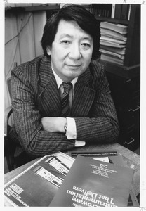 Hajime Sakai seated at desk with publications