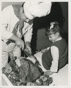 Chef carving turkey for young client