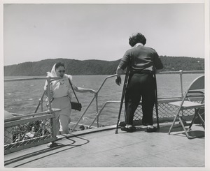 Woman coming up the stairs and person standing at railing