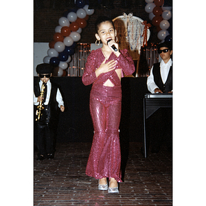 A girl sings and dances with a microphone at the Festival Puertorriqueño