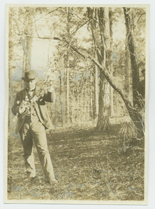 Booker T. Washington examines a tree branch