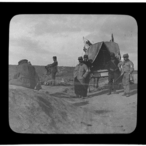 Men stand at the back of a horse-drawn wagon