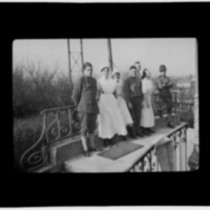 Nurses and soldiers pose on a porch