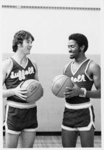 Suffolk University men's basketball players Donovan Little (right) and team captain Patrick Ryan (left), holding basketballs, circa 1978-1979