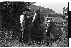 On-duty RUC officer with gun, patting a horse's head while on patrol, Downpatrick
