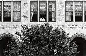 Man looking out the window of a building at Boston College