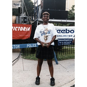Portrait of a young woman holding a trophy at Festival Betances.