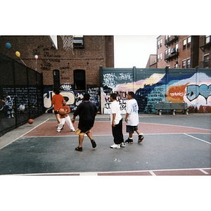 Young boys playing basketball on a court in the Villa Victoria neighborhood.