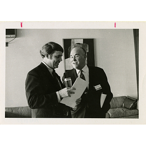 Two men stand and converse at a Boys' Club meeting