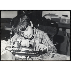 A boy builds a model ship for his art class at the Boys and Girls Clubs of Boston