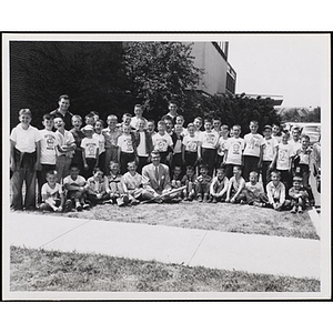 A group of boys pose for a group portrait outdoors with 1955 Rotary Club President and Vice President of WBZ Wilmer C. Swartley (seated, center)
