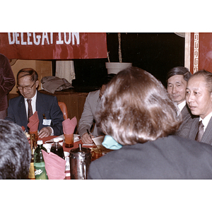 Henry Wong sits at a restaurant table with members of the Guangdong Province delegation
