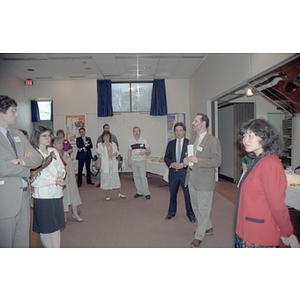 Man addresses those standing and listening at a food tasting event