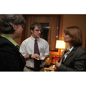 Jordan Munson and a woman converse with Elizabeth Hill