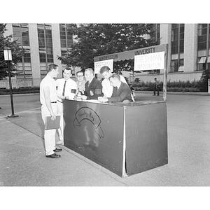 Several men at a Husky Key Freshman Information booth