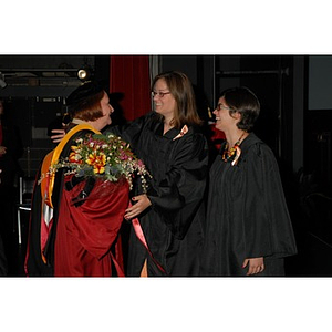 Students present Patricia Kiladis, a professor, with flowers during the School of Nursing convocation