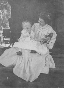 Eleanor T. C. Foote seated on a porch steps with infant son Wilder in her lap