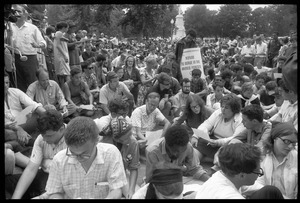 Anti-Vietnam war protesters sitting down after Assembly of Unrepresented People peace march, raising signs 'Refuse to serve in the armed forces'