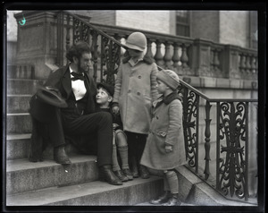 Lincoln Caswell, Abraham Lincoln impersonator, seated on a stoop, talking with children