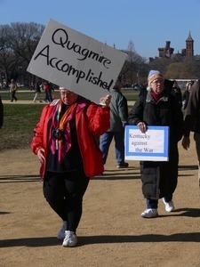 Protester on the National Mall, marching against the War in Iraq, carrying sign reading 'Quagmire accomplished'