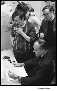 Malcolm Boyd at Boston University: Boyd (seated) in the BU News room with (l-r) Raymond Mungo, Joe Pilati kissing an unidentified woman, and an unidentified man