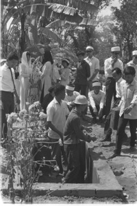 Soldiers dig common grave for their dead colonel, his wife and their five children who were slain by the Vietcong during the first hour of battle; Saigon.