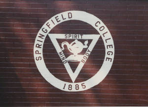 Springfield College seal painted on a brick wall, ca. 1990