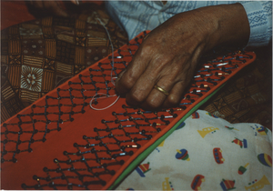 Needlework: Kam Phang places a bead at the center of the Komrope Trie, 1987